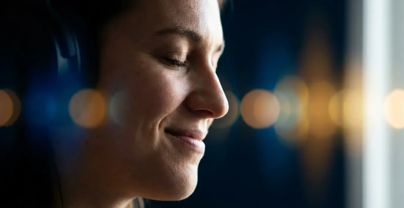 Portrait en plan rapproché d'une personne en état d'écoute profonde, yeux fermés, entourée d'ondes sonores abstraites